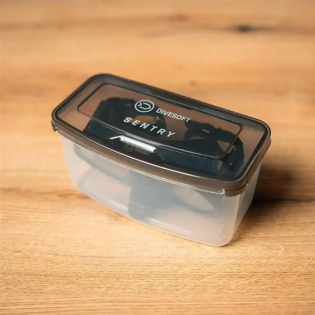 Taucherbrille Divesoft Sentry in transparenter Aufbewahrungsbox auf Holztisch