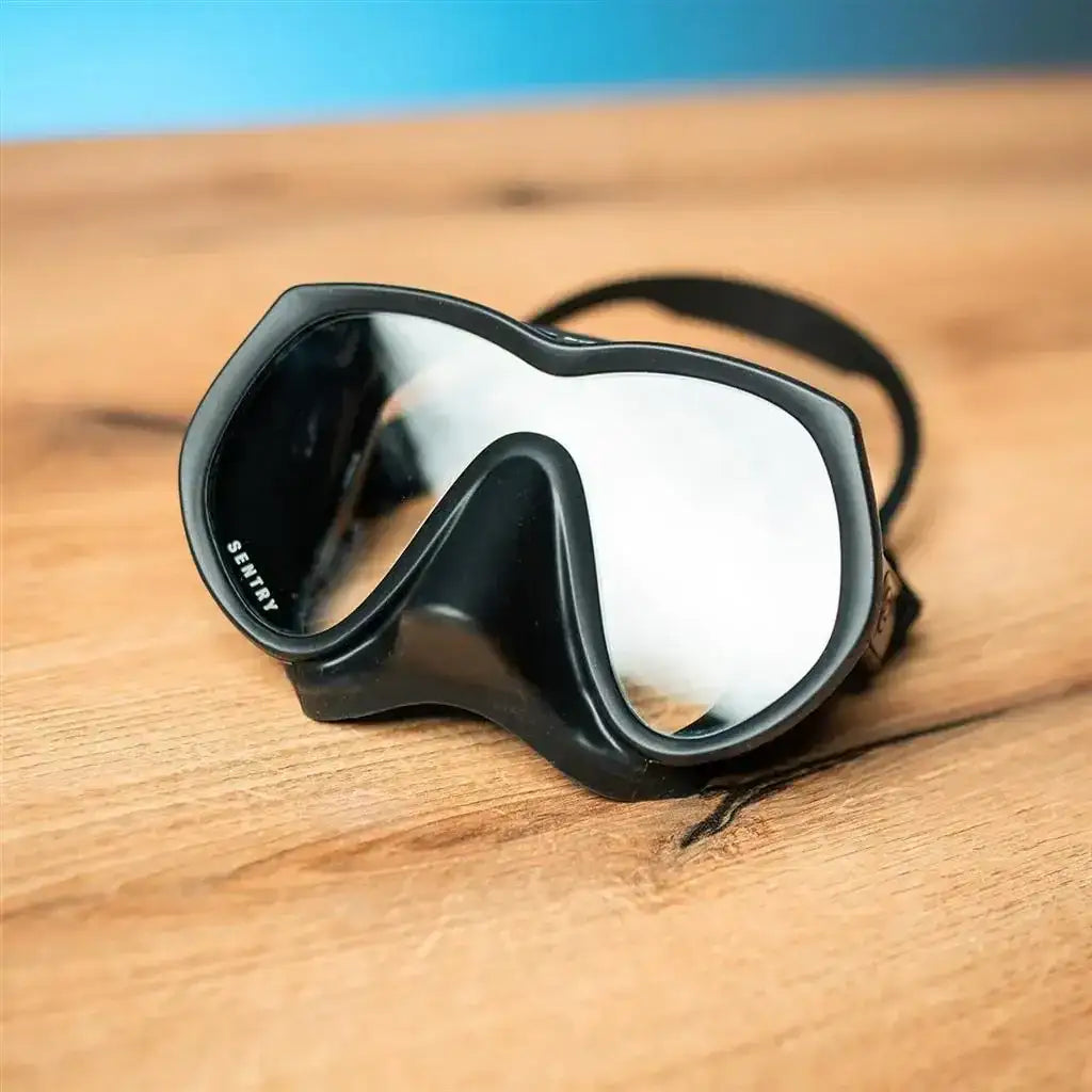 Schwarze Tauchmaske Sentry mit Silikonband auf Holztisch, Nahaufnahme, Tauchausrüstung