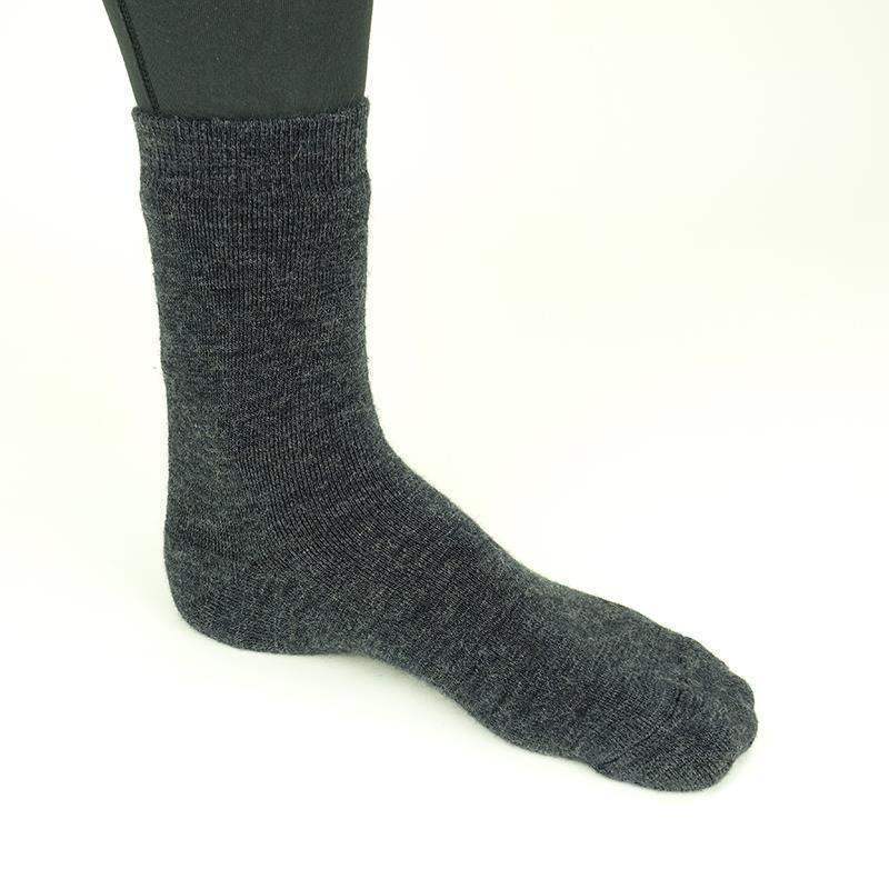 Dunkelgraue Thermosocke für Taucher, seitlich am Bein fotografiert, auf hellem Hintergrund.